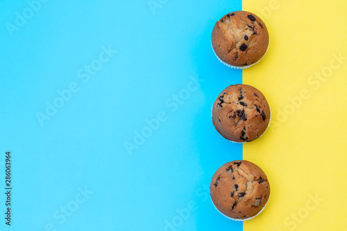 muffins with chocolate on blue and yellow background