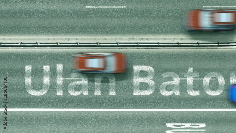 Aerial top down view of the road with cars revealing Ulan Bator caption. Car travel in Mongolia conceptual clip
