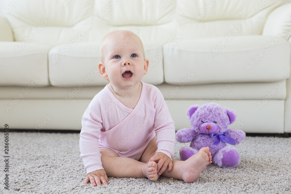 Children and childhood concept - Little baby girl sitting on the floor Children and childhood concept - Little baby girl sitting on the floor