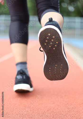 women jogging on sport track fucus on shoe tread