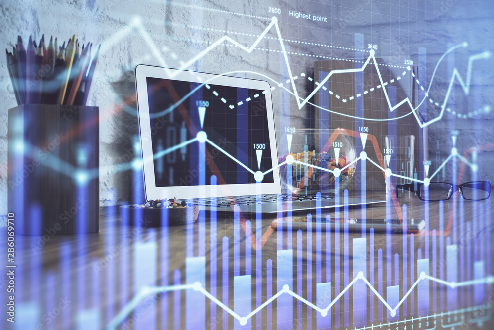Financial graph colorful drawing and table with computer on background. Double exposure. Concept of international markets. Financial graph colorful drawing and table with computer on background. Double exposure. Concept of international markets.