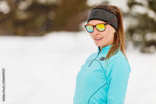 Winter workout. Girl wearing sportswear and sunglasses.