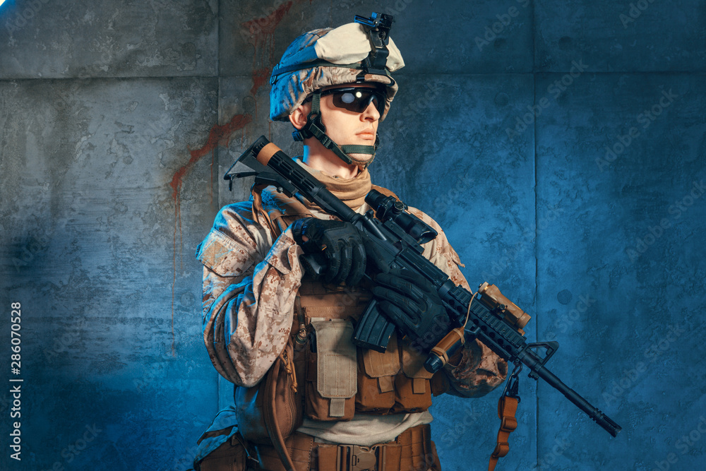 Special forces United States soldier or private military contractor holding rifle. Image on a dark background Special forces United States soldier or private military contractor holding rifle. Image on a dark background