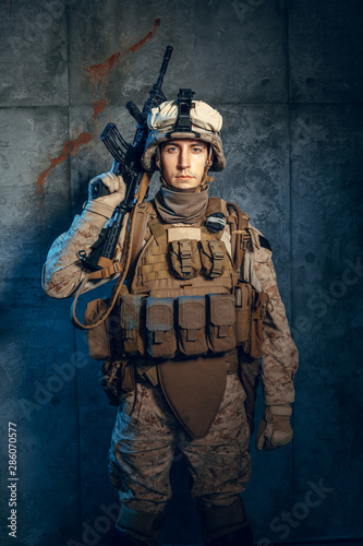 War, army, weapon concept. Private military contractor holding rifle