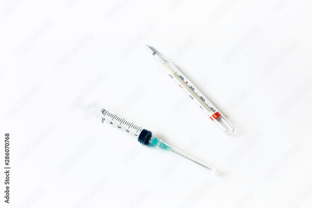 Empty syringe and thermometer closeup isolated on white background. High resolution. Injection. Vaccination. The medicine. Medical procedures and procedures. Empty syringe and thermometer closeup isolated on white background. High resolution. Injection. Vaccination. The medicine. Medical procedures and procedures.