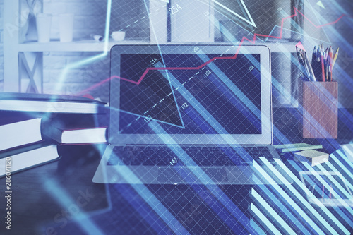 Financial graph colorful drawing and table with computer on background. Double exposure. Concept of international markets.