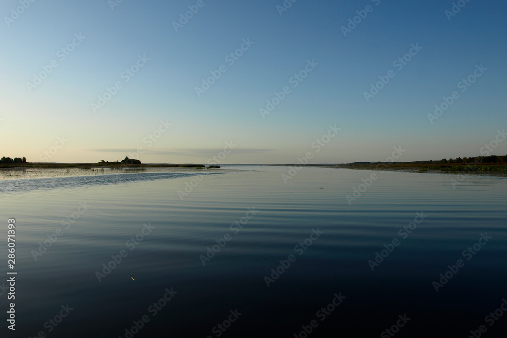 Scenic sunrise panorama view, morning fog on lake, misty reflection in steaming water, Latvia