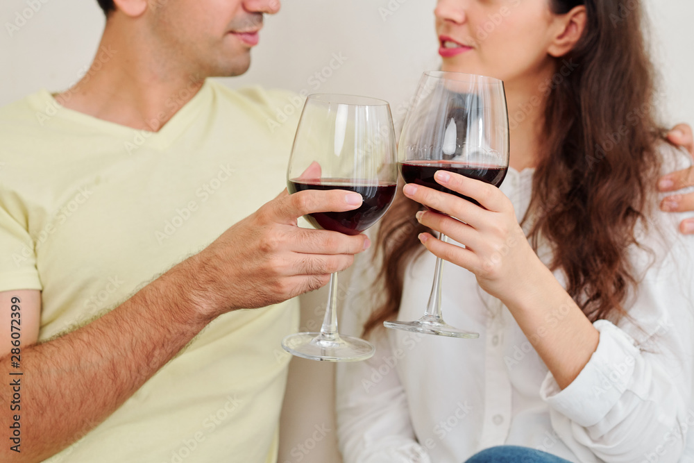 Cropped image of young couple enjoying romantic evening at home with tasty red wine Cropped image of young couple enjoying romantic evening at home with tasty red wine