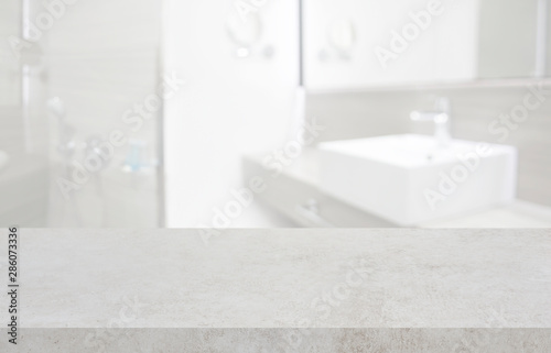 Stone table top and blurred hotel bathroom interior as background