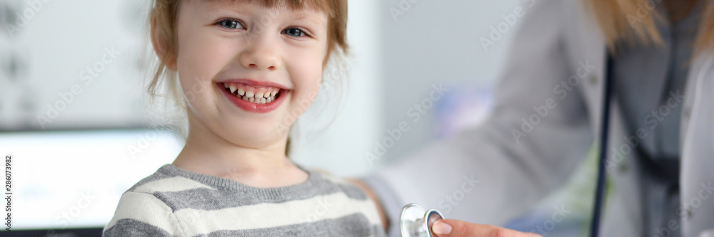 Smiling cute little girl with doctor measuring heart beat with stethoscope portrait Smiling cute little girl with doctor measuring heart beat with stethoscope portrait