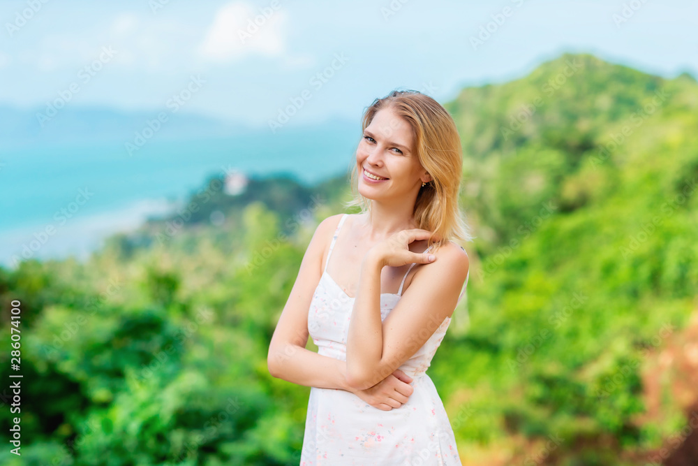 Smiling happy woman is standing at summer tropical island background. Smiling happy woman is standing at summer tropical island background.