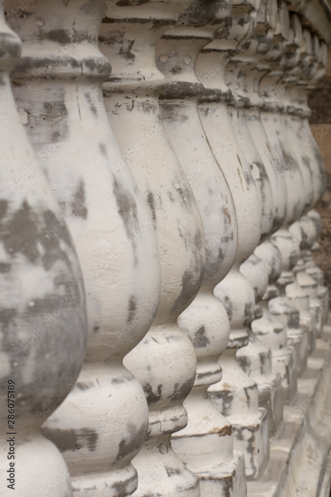 Antique balusters of gray color with cracked white paint. Linear perspective. Creative vintage background. Balustrade. Antique balusters of gray color with cracked white paint. Linear perspective. Creative vintage background. Balustrade.