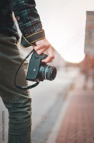 Man hipster with retro photo camera in hand, Fashion Travel Lifestyle outdoor foggy nature on city street background