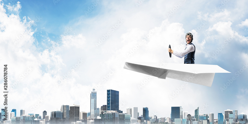 Aviator driving paper plane above business center Aviator driving paper plane above business center