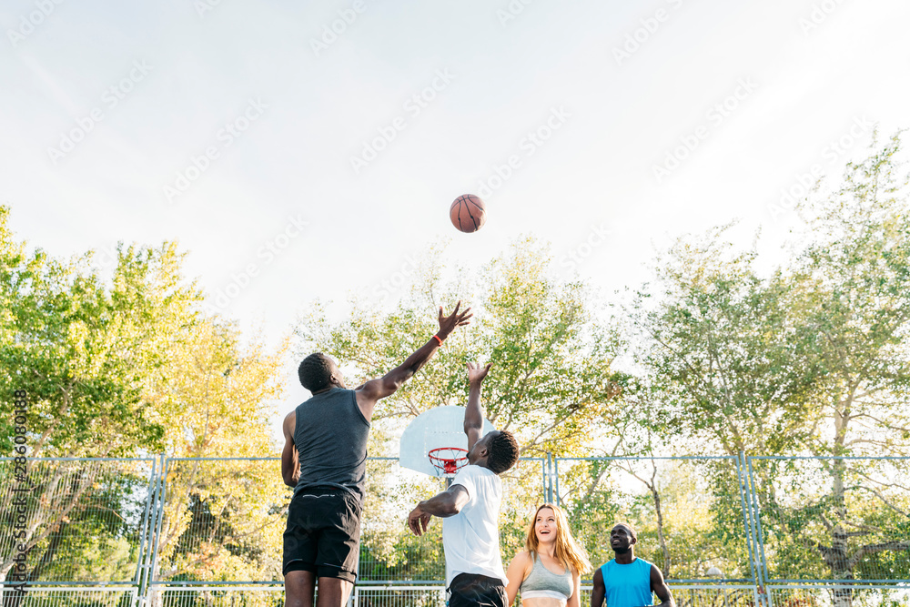Teenager group having fun playing basketball