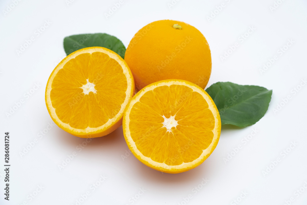 Half of orange and whole with green leaf isolated on white background Half of orange and whole with green leaf isolated on white background