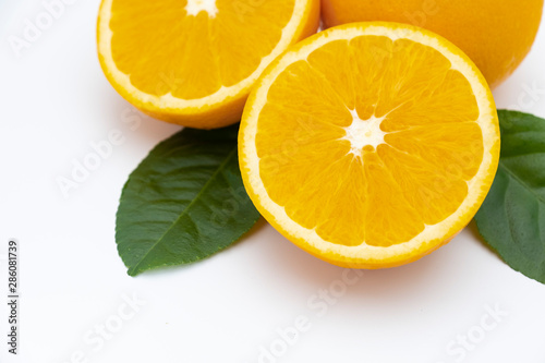 Half of orange and whole with green leaf isolated on white background