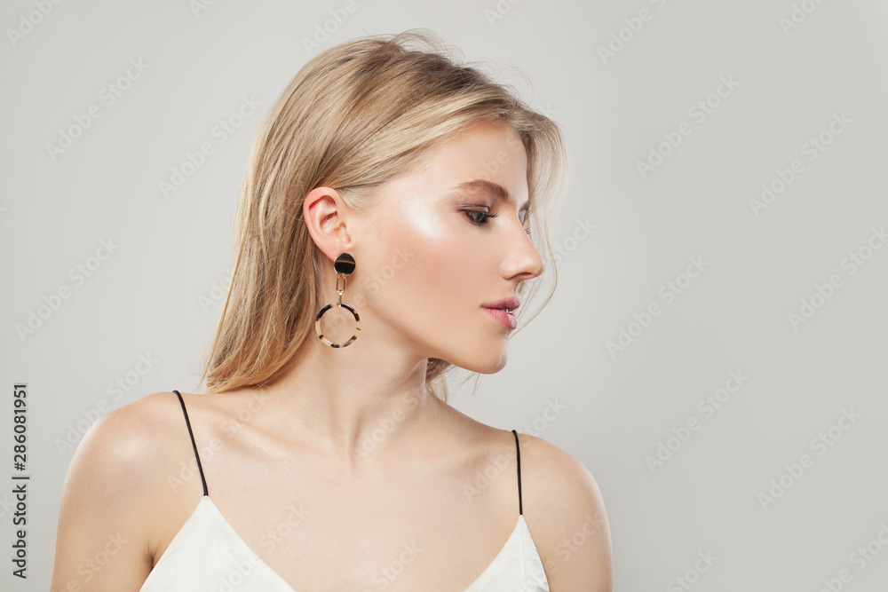 Portrait of fashion pretty woman with blonde hair, makeup and golden earrings on white background. Perfect female profile Portrait of fashion pretty woman with blonde hair, makeup and golden earrings on white background. Perfect female profile