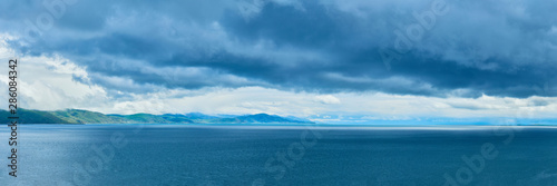 the endless water expanses of the lake Sevan on a cloudy day with clouds in the sky. © StockAleksey