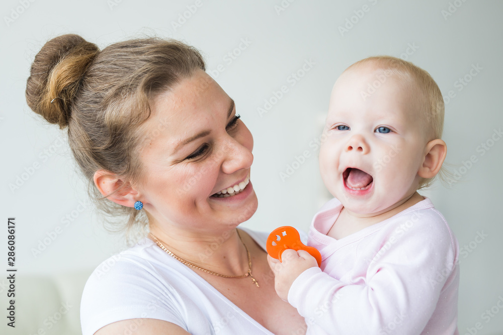Motherhood, family and children concept - Young mother with her cute little baby at home close-up Motherhood, family and children concept - Young mother with her cute little baby at home close-up