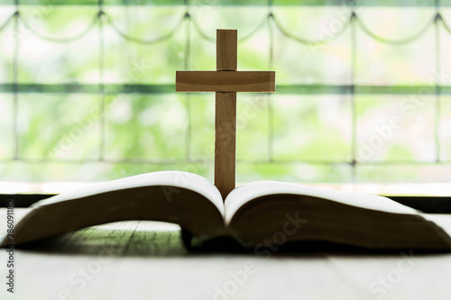 Crosses that open above the Bible on a wooden table