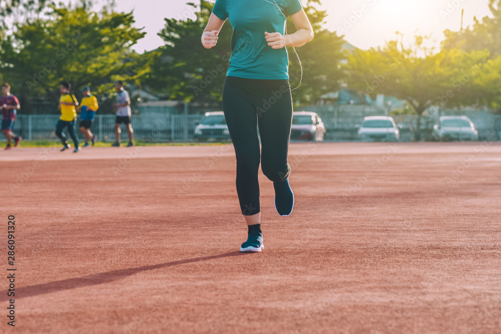 Runner Women jogging or running in evening at sunlight Runner Women jogging or running in evening at sunlight