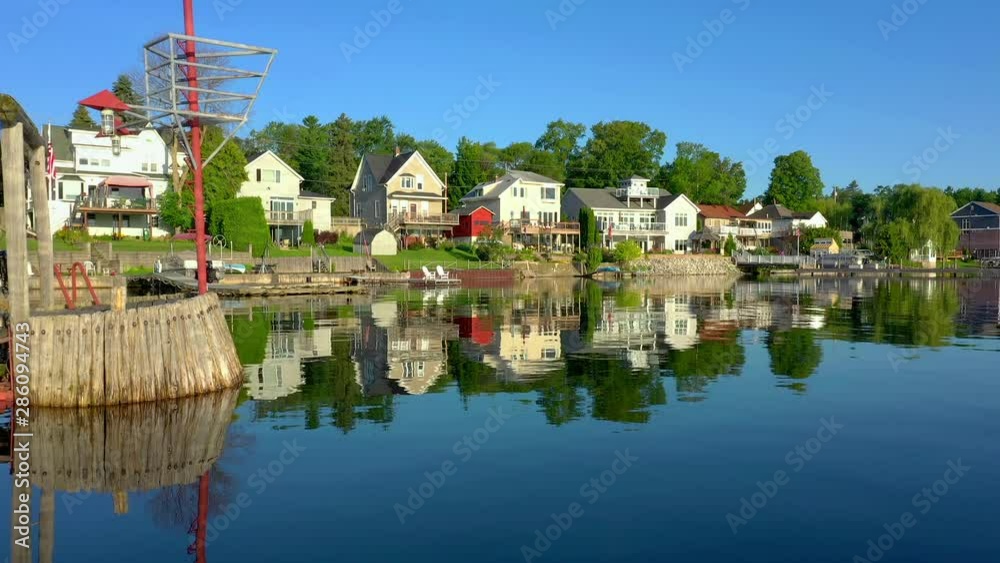 Scenic waterfront homes with reflection, tranquil water, low drone viewpoint. Scenic waterfront homes with reflection, tranquil water, low drone viewpoint.