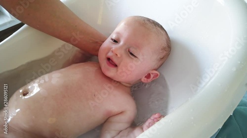 Mother take a bath for his newborn baby. Baby bath time