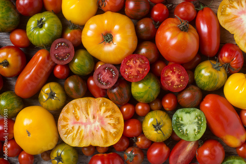 Fotografie, Tablou Close up of colorful tomatoes, some sliced, shot from above