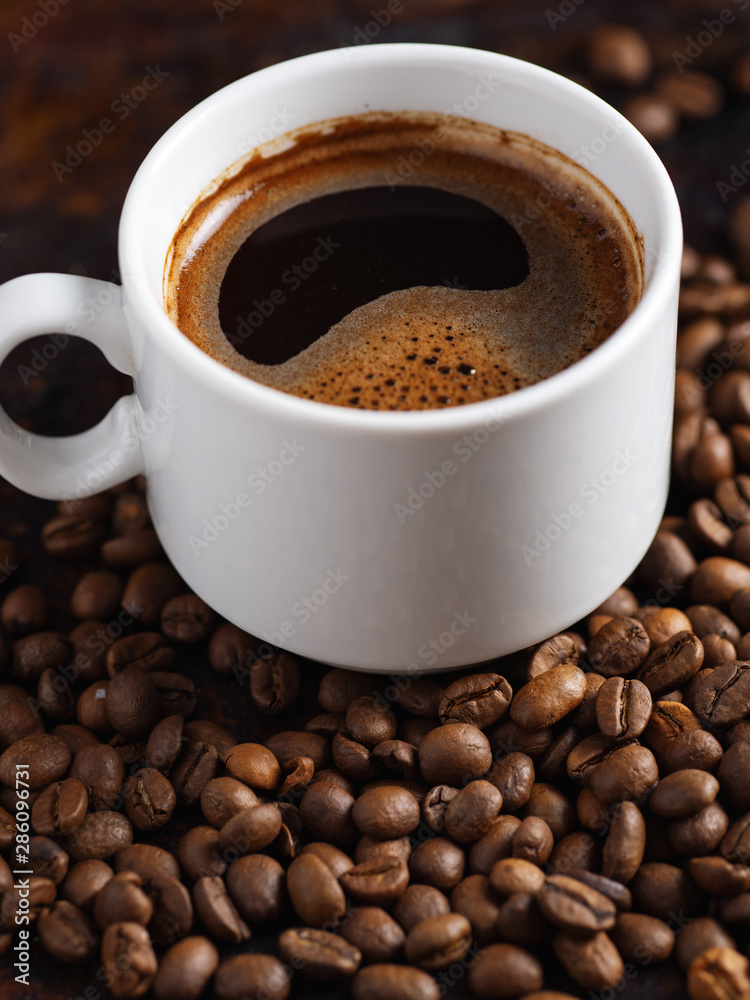 White Cup of espresso close-up on roasted coffee beans White Cup of espresso close-up on roasted coffee beans