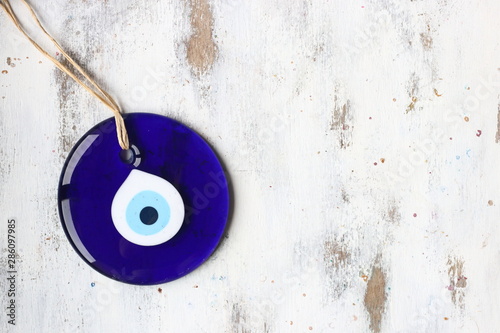 Evil eye bead, Turkish nazar bead on a white wooden background photo