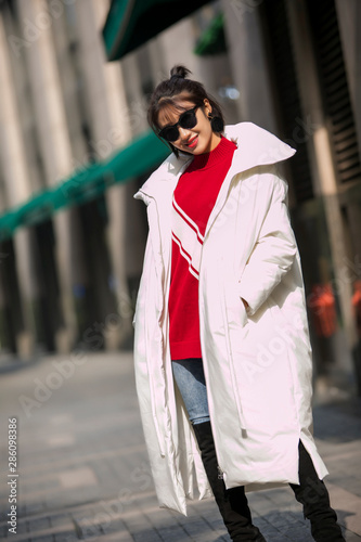 Asian girl in white down jacket on the street