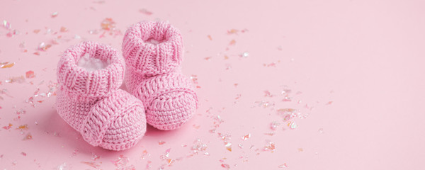Pair of small baby socks on pink background with copy space for your warm message, baby shower, first newborn party background, copy space, cute minimal postcard