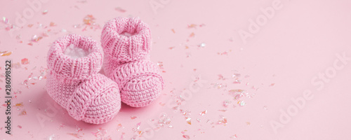 Canvas Pair of small baby socks on pink background with copy space for your warm messag