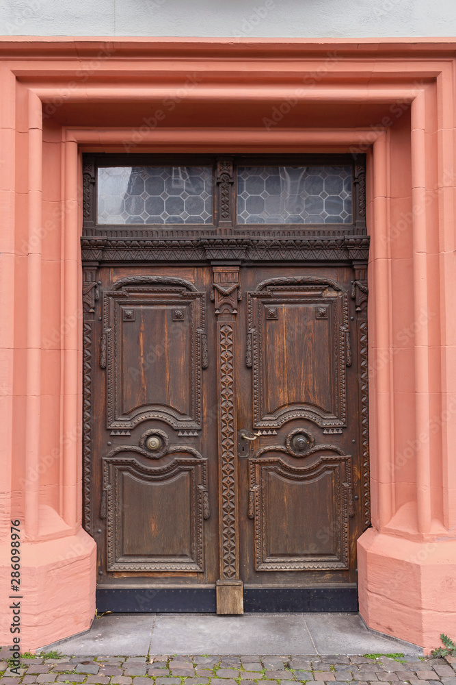 wooden door with a beautiful wooden ornament in the historical part of the German city of Mainz