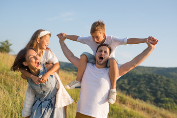 Happy family in nature. Happy family: mother, father, children son and daughter. life is made of little things.
