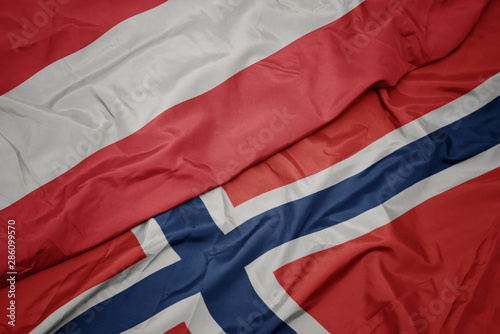 waving colorful flag of norway and national flag of austria.