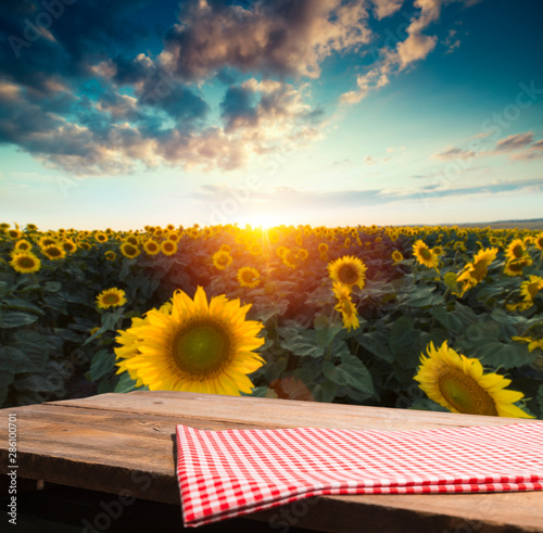 Empty wooden plank with Sunflower field background