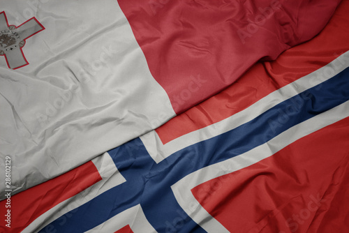 waving colorful flag of norway and national flag of malta.
