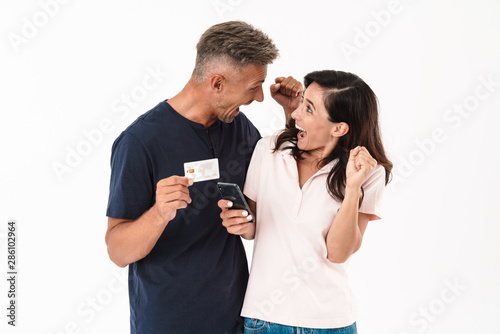 Cheerful couple wearing casual outfit standing isolated