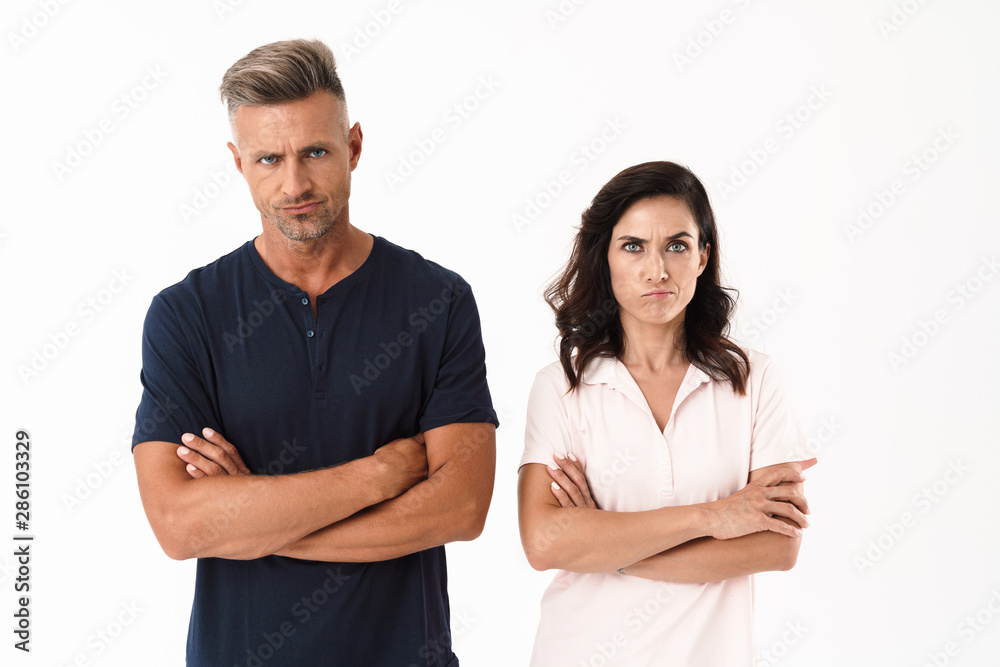Angry attractive couple wearing casual outfit standing isolated