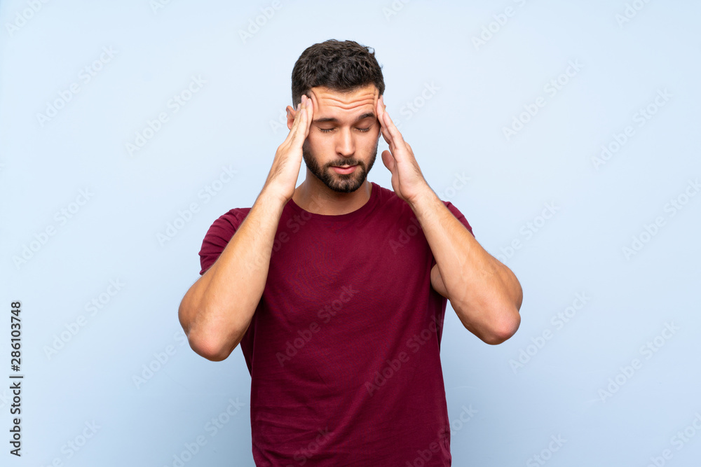 Fototapeta premium Handsome man over isolated blue background with headache