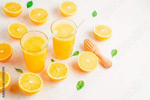 Fresh Orange juice in glass and fresh citrus around. Healthy drink on white. Top view.