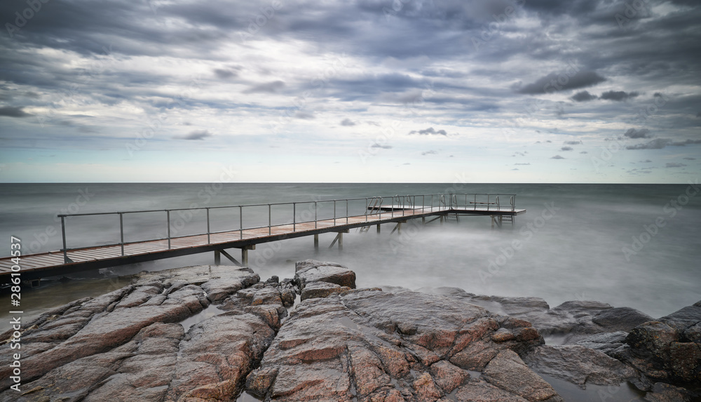 Steg führt ins Wasser am Strand von Sandvig auf Bornholm an einem windigen Sommertag