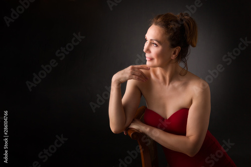portrait of a sensual fifty year old woman on grey studio background
