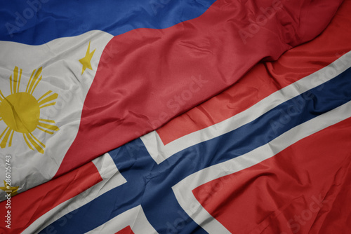waving colorful flag of norway and national flag of philippines.