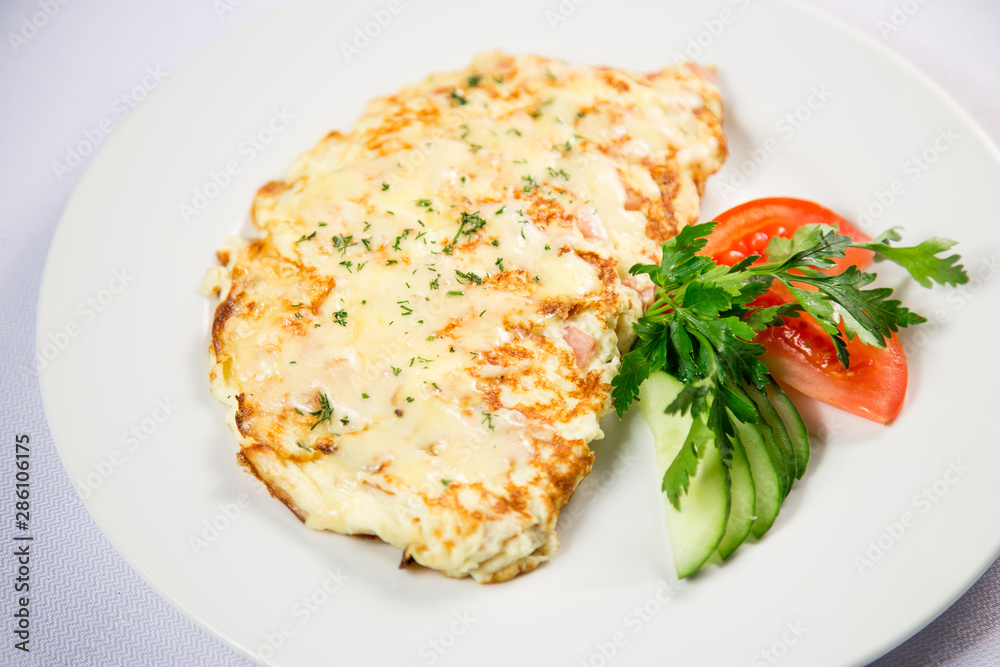 fried eggs and omelet with vegetables on a white background fried eggs and omelet with vegetables on a white background