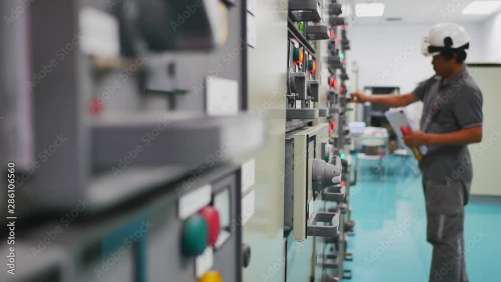 Engineer working in electricity substation building for check electrical control equipment by ampere meter , Industrial and technology concept Engineer working in electricity substation building for check electrical control equipment by ampere meter , Industrial and technology concept