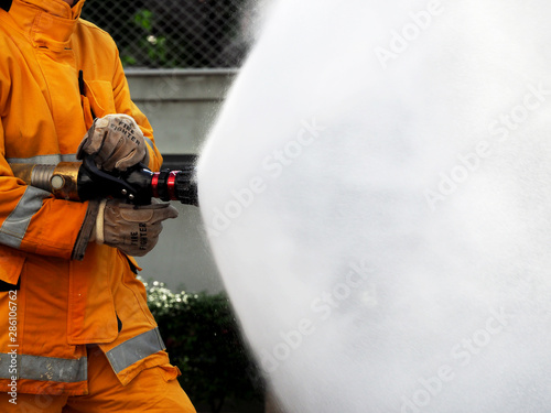 firefighter training., fireman using water and extinguisher to fighting with fire flame in an emergency situation