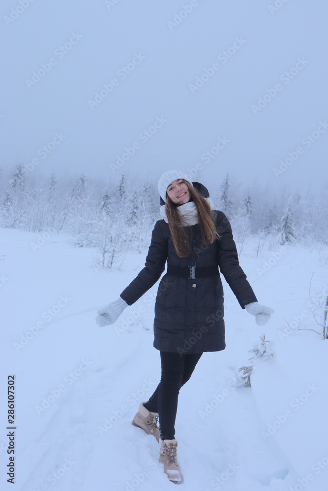 Portrait of young woman in winter - full size with frozen forest background